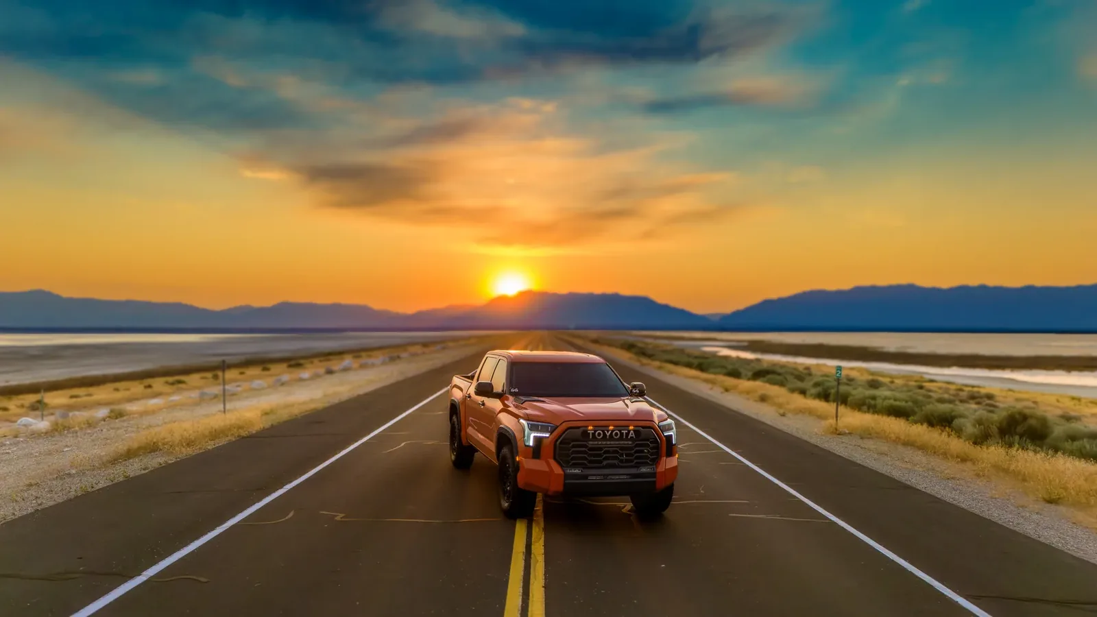 Orange Tundra facing camera at the Antelope Island Causeway, sunset behind.